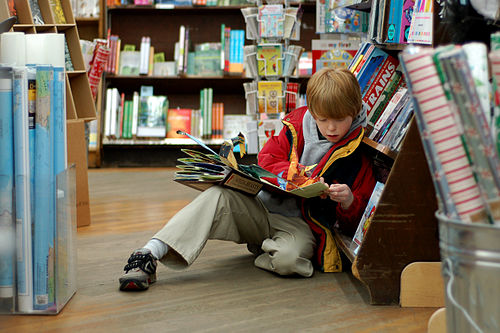 Kind liest in Buchhandlung